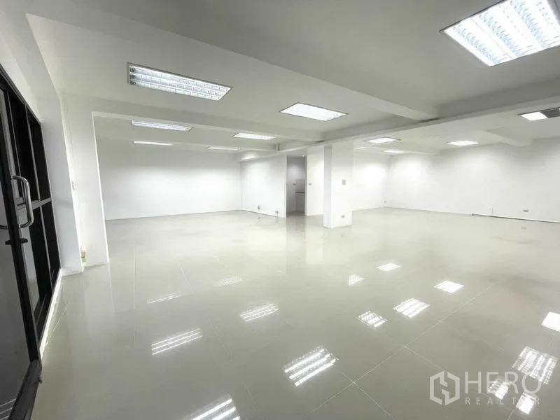办公空间 出租在Khlong Toei, Bangkok - 大面积无柱办公区，多组灯具与整面窗墙。