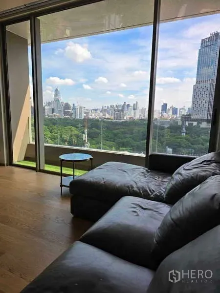 公寓 出租或出售在Bang Rak, Bangkok - 转角沙发靠落地玻璃，享受无遮挡的公园与高楼景致。