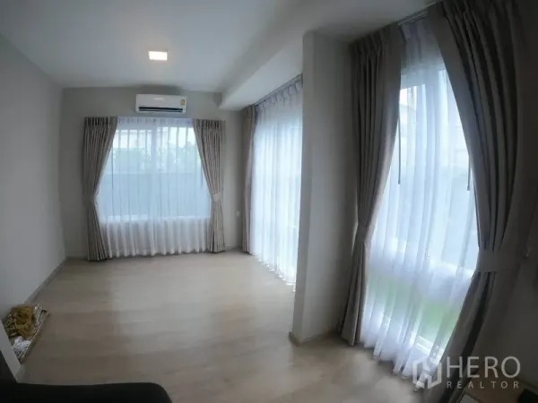 独立式住宅 出租在Prawet, Bangkok - 角落多功能房，落地窗与纱帘引入自然光。