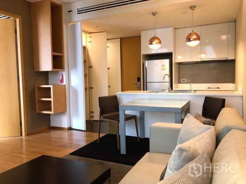 Condominium for rent in Watthana, Bangkok - Compact dining nook beside the kitchen island with copper pendant lights.
