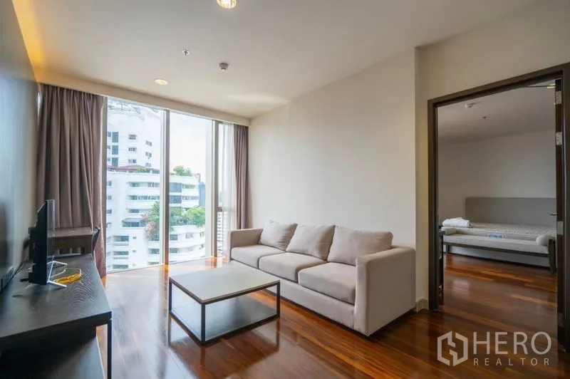 公寓 出租在Khlong Toei, Bangkok - 次客厅配沙发与电视柜，大窗采光，与卧室相连
