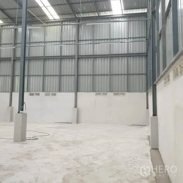 Warehouse for rent in Khlong Toei, Bangkok - High‑ceiling warehouse interior with steel columns, skylights, and concrete floor.