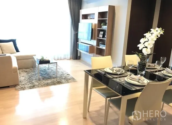 คอนโด ให้เช่าในSathon, Bangkok - ห้องนั่งเล่นและรับประทานอาหารแบบโอเพ่นพร้อมโซฟา พรม โต๊ะกระจก และผนังทีวีบิลต์อินในคอนโดสาทร