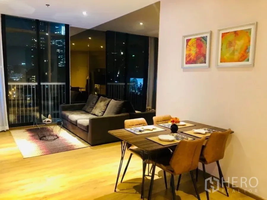 Condominium for rent in Khlong Toei, Bangkok - Another view of the open-plan living and dining space with sofa, dining set and night city outlook.