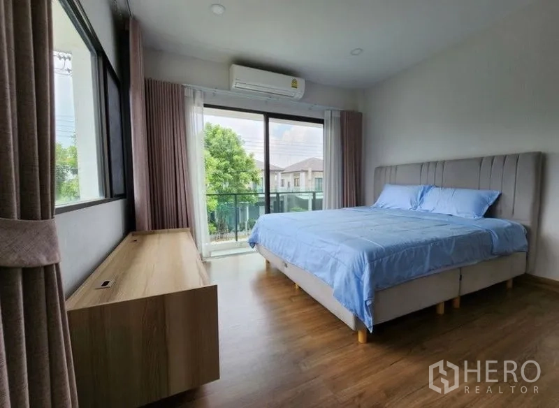 独立式住宅 出租在Prawet, Bangkok - 主卧带阳台与木地板，大窗眺望绿景。
