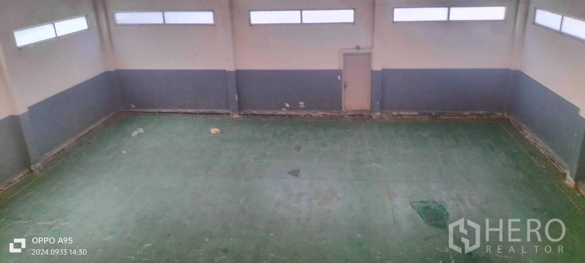 Factory for rent in Khlong Luang, Pathum Thani - Overhead view of a clear bay with green epoxy flooring and wall windows.