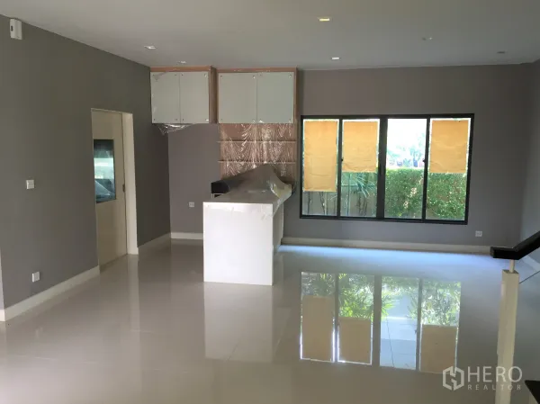 Detached House for rent or sale in Bang Kapi, Bangkok - Open-plan living and dining area with glossy tiled floors and large windows.