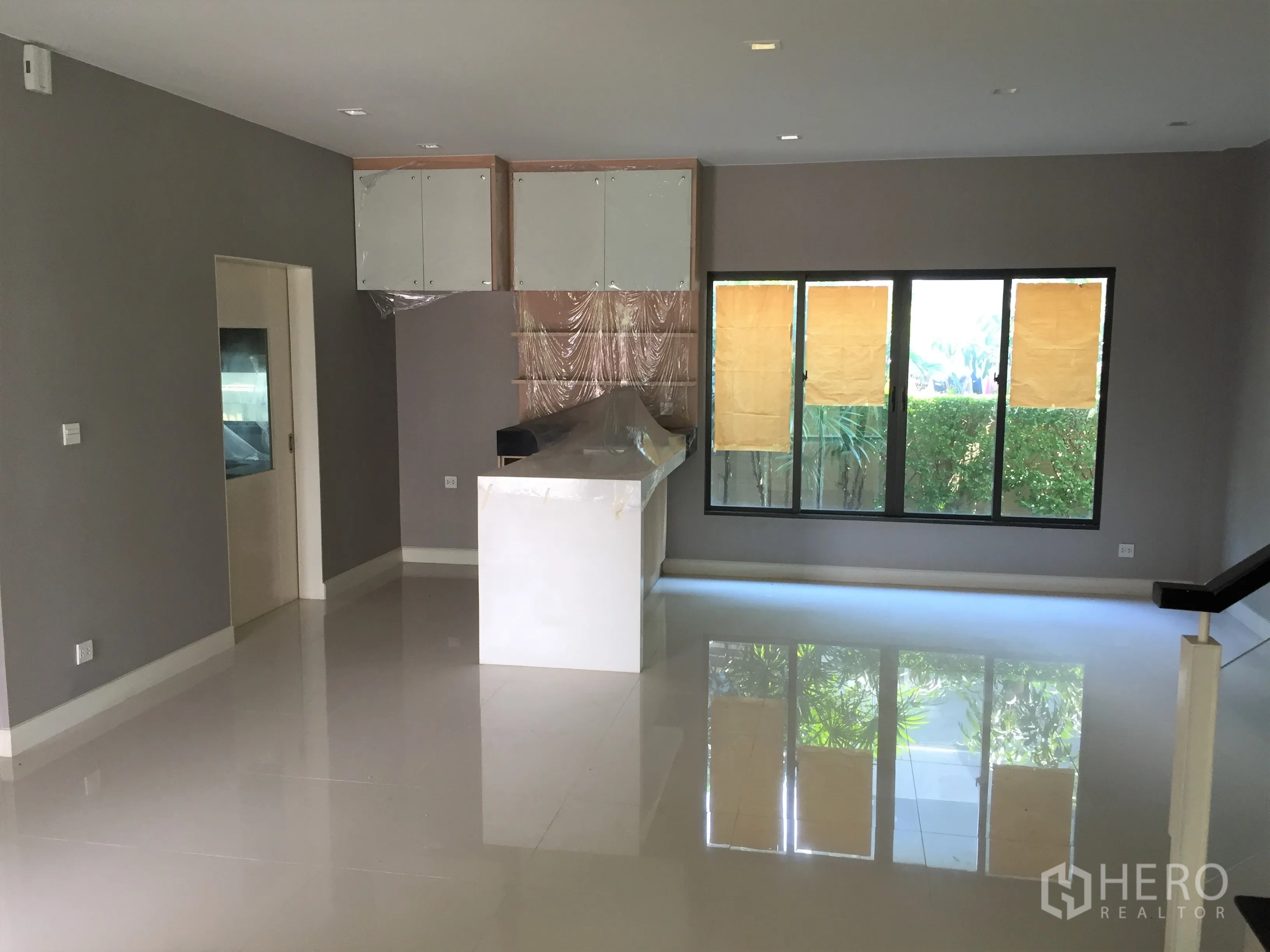 Detached House for rent or sale in Bang Kapi, Bangkok - Open-plan living and dining area with glossy tiled floors and large windows.