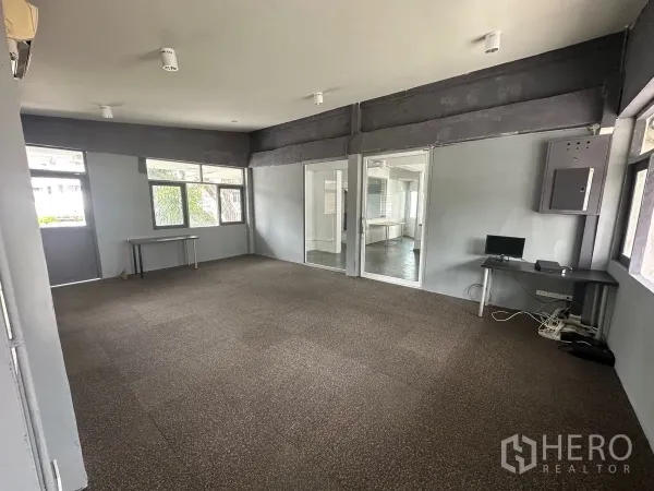 Home Office for rent in Chatuchak, Bangkok - Spacious open-plan office room with carpet tiles, glass partition and multiple windows.