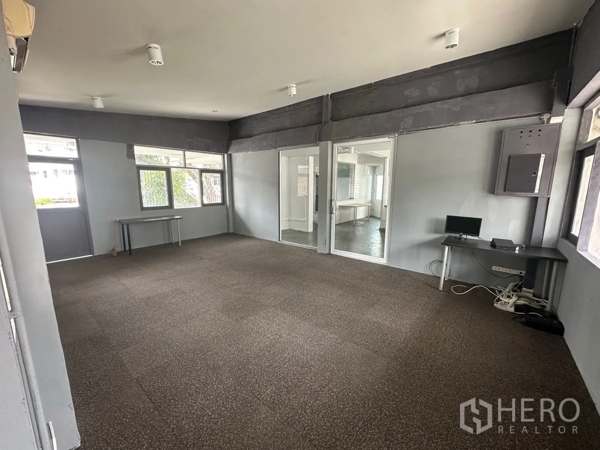 Home Office for rent in Chatuchak, Bangkok - Spacious open-plan office room with carpet tiles, glass partition and multiple windows.