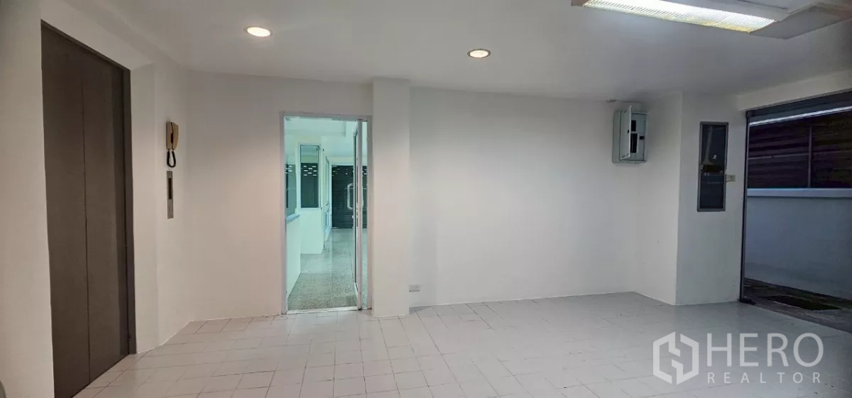 办公空间 出租在Bueng Kum, Bangkok - 电梯前厅，嵌灯天花与通往办公区的玻璃门。