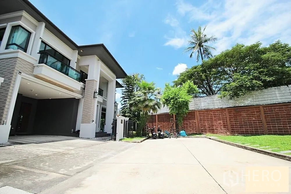 Detached House for rent in Bang Khae, Bangkok - Two‑storey detached house facade with balconies, carport and wide driveway.