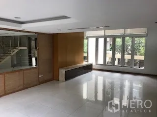 Townhouse for rent or sale in Yan Nawa, Bangkok - Large living area with glossy tile floors and full-height windows.