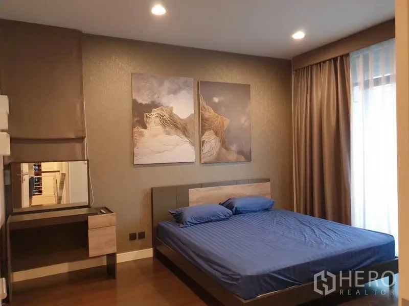 Detached House for rent in Bang Kapi, Bangkok - Primary bedroom with feature wall art, double bed, dressing table, and floor-to-ceiling curtains.