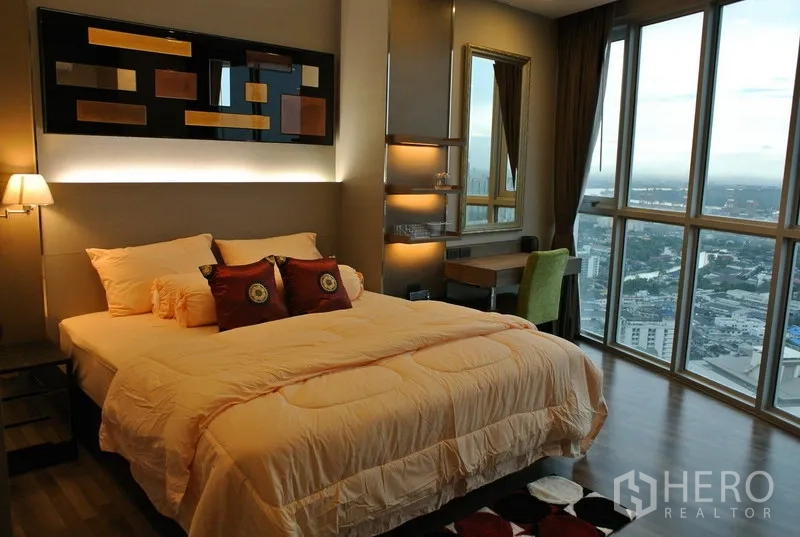 คอนโด ให้เช่าหรือขายในWatthana, Bangkok - ห้องนอนมาสเตอร์กว้าง เตียงขนาดใหญ่ ผนังตกแต่งพร้อมไฟ โต๊ะทำงาน และหน้าต่างกระจกสูงจรดเพดานชมวิวเมือง