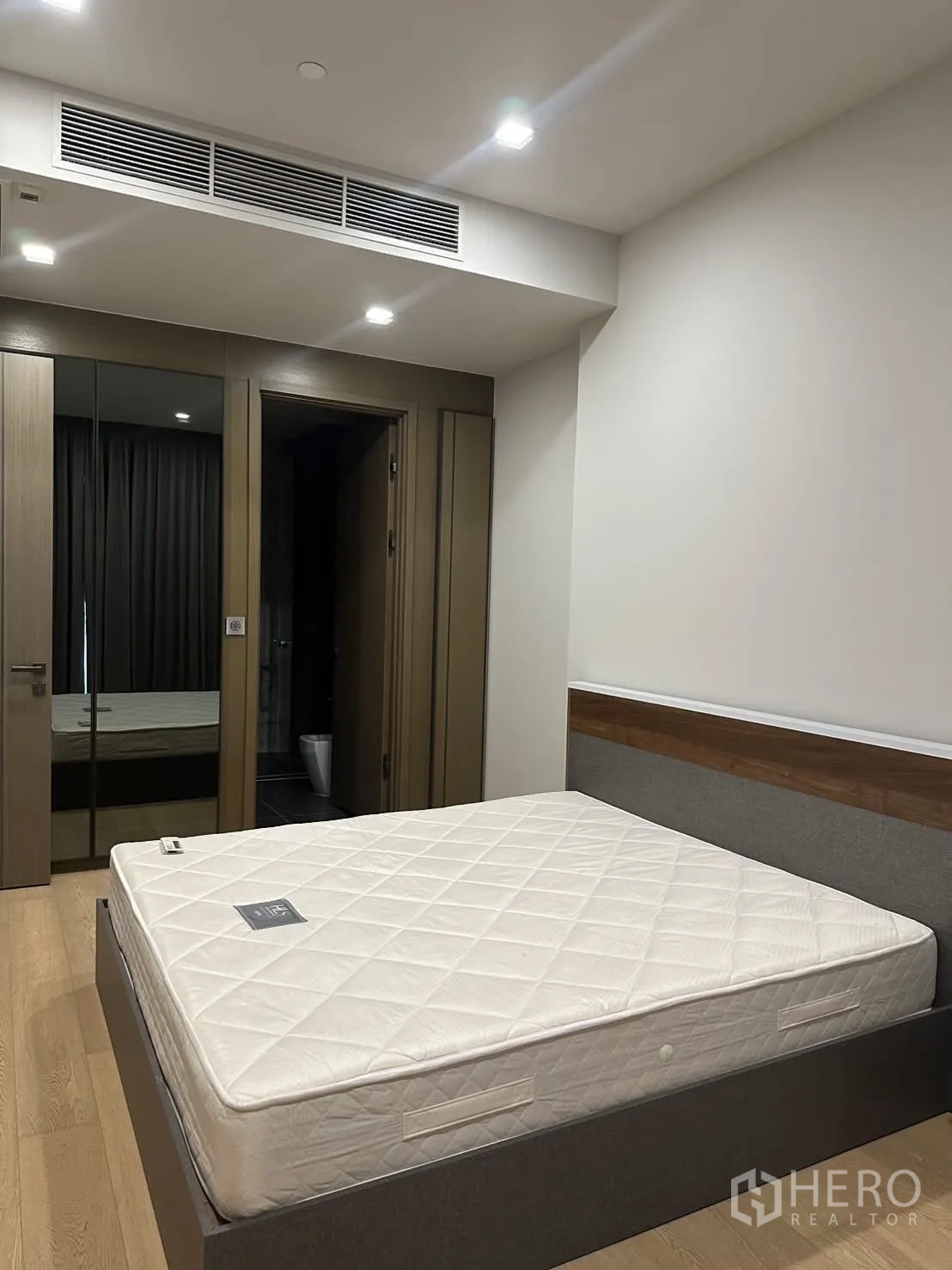 คอนโด for rent or sale in Watthana, Bangkok - ห้องนอนที่สองมีเตียง ตู้เสื้อผ้าบานกระจก และประตูห้องน้ำในตัว.