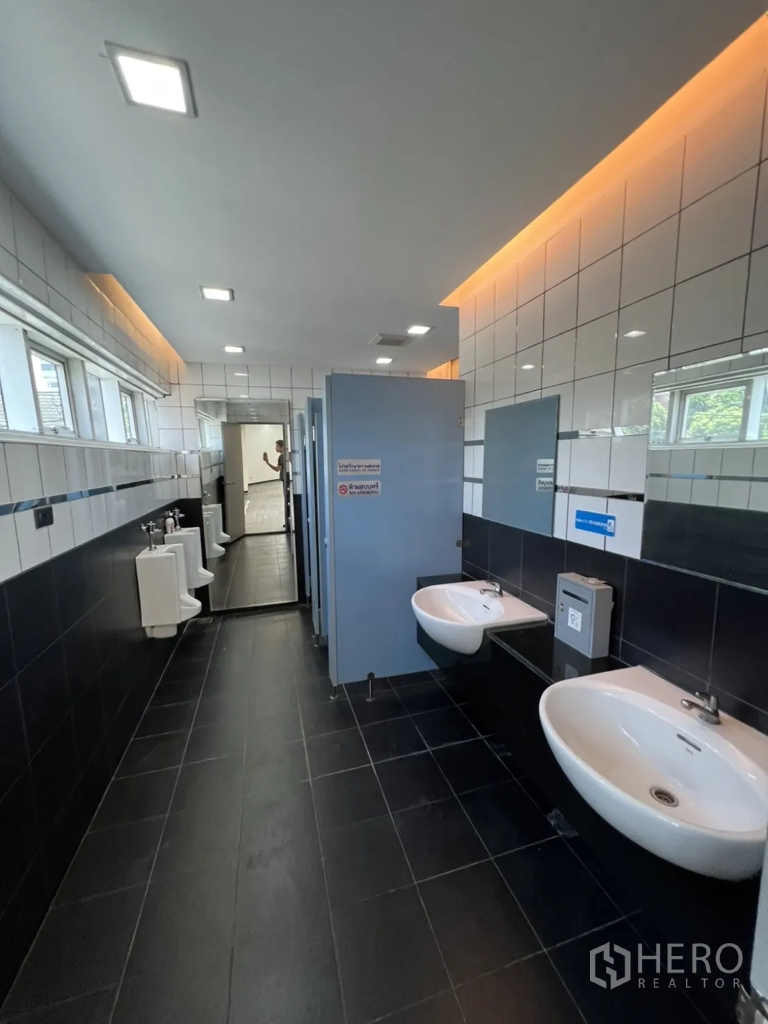Retail Space for rent in Sathon, Bangkok - Long tiled restroom with sinks, mirrors, urinals and cubicles.