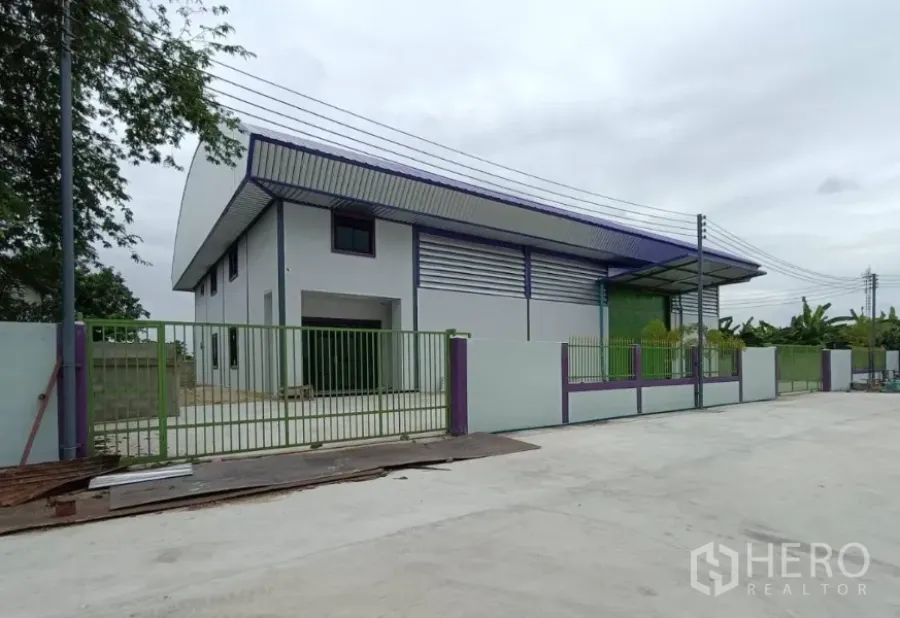 工厂 出租在Lam Luk Ka, Pathum Thani - Lam Luk Ka现代可租工厂，绿色大门与宽阔车道，金属屋顶。