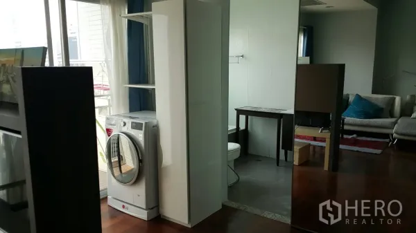 公寓 出租在Watthana, Bangkok - 室内洗衣区配前置洗衣机，邻近浴室与阳台窗户。