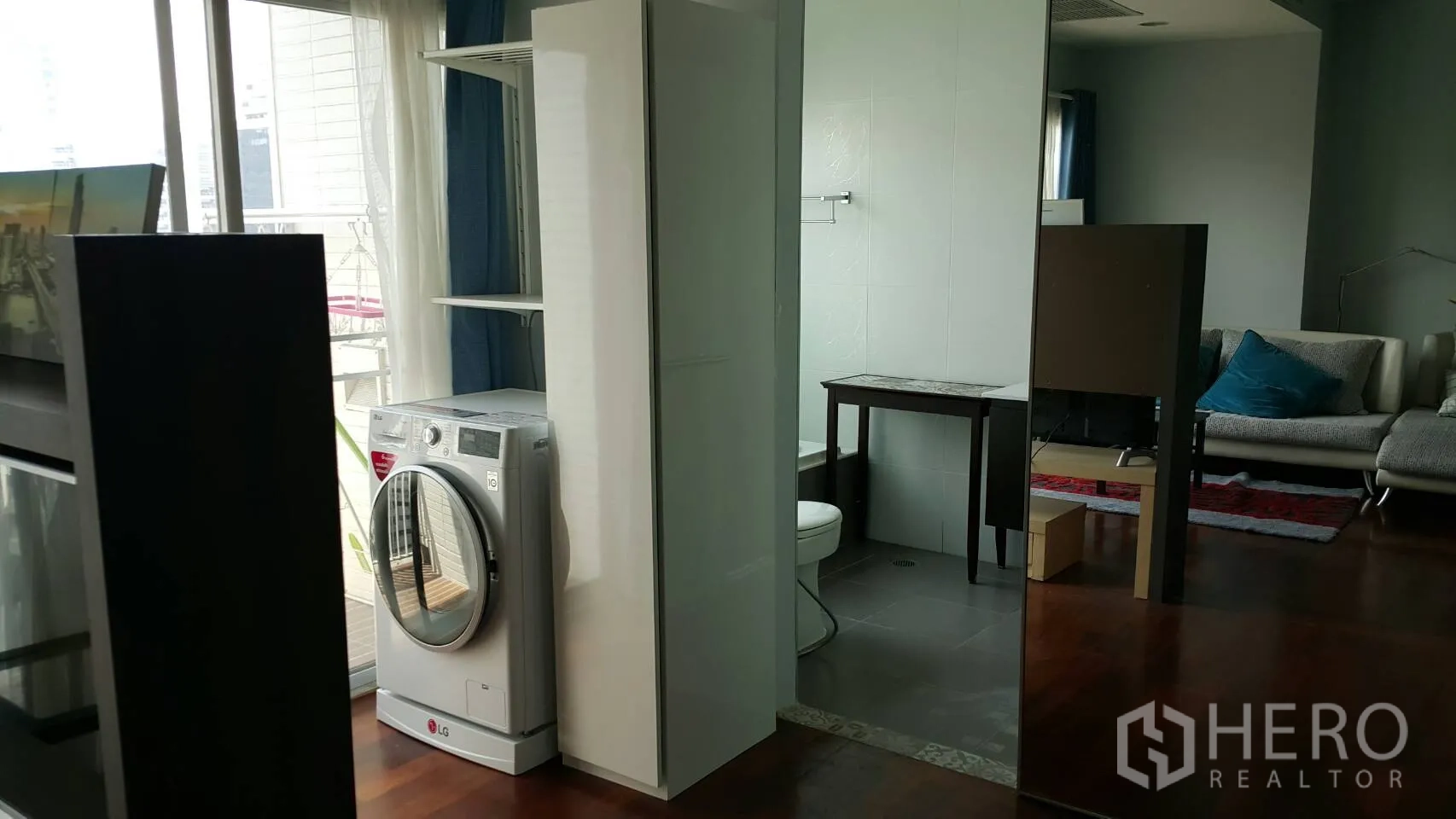 公寓 出租在Watthana, Bangkok - 室内洗衣区配前置洗衣机，邻近浴室与阳台窗户。