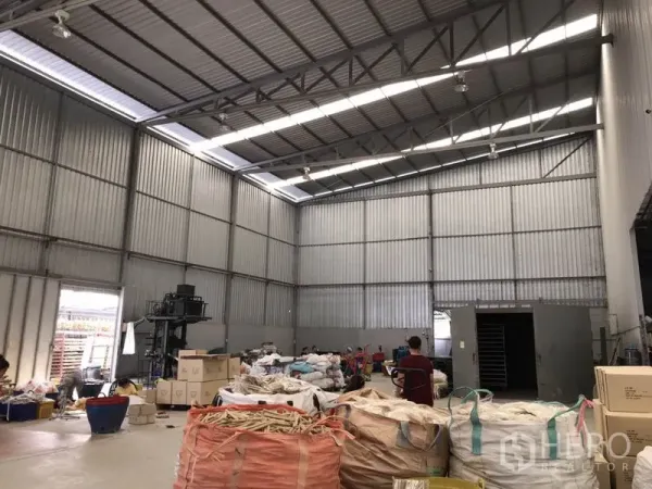 Warehouse for rent in Mueang Samut Prakan, Samut Prakan - Tall steel-clad warehouse bay with skylight strips, roller shutter access and wide column-free space.