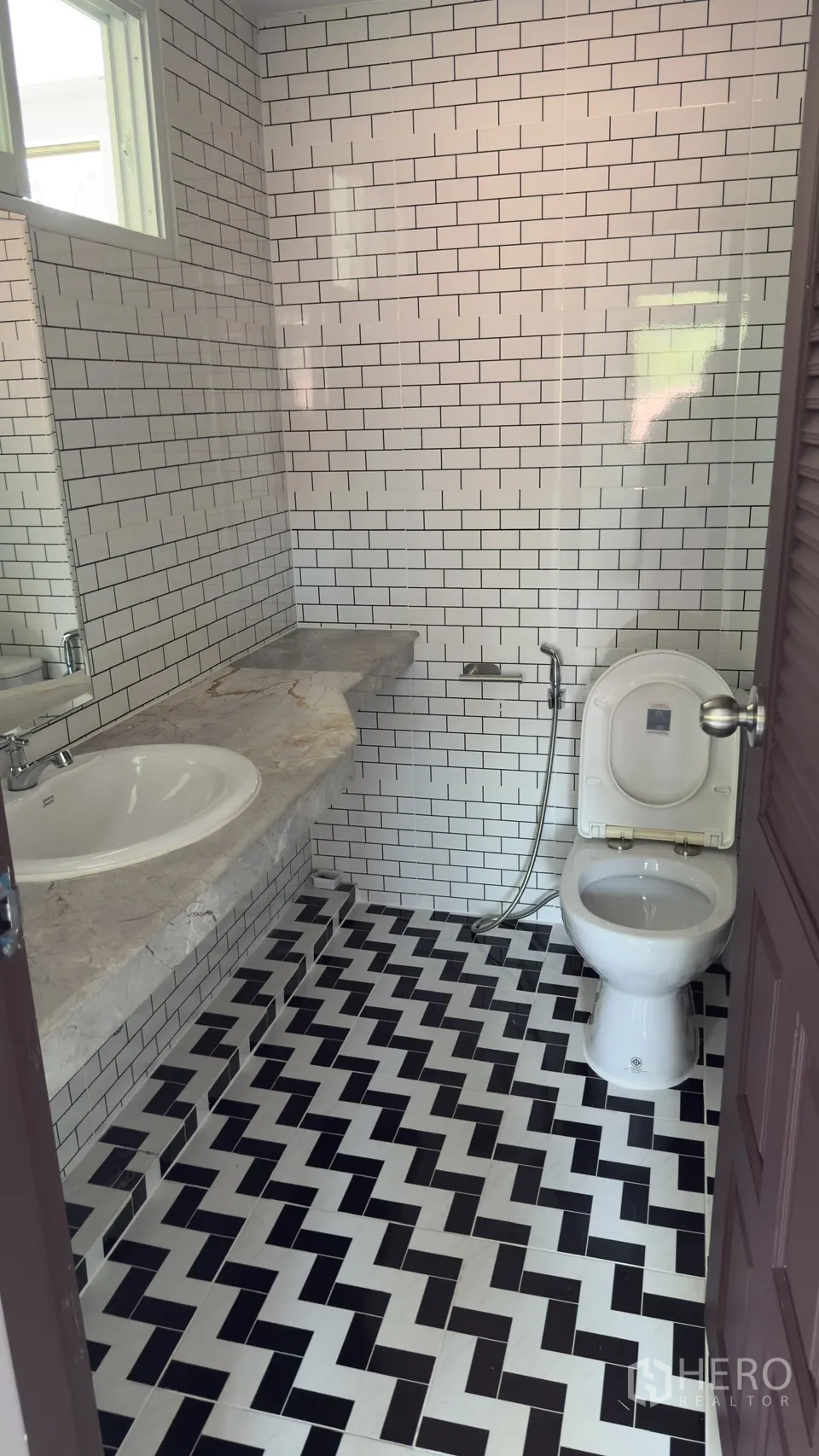 联排别墅 for rent in Watthana, Bangkok - 小巧浴室，白色地铁砖墙、黑白地砖、石质台面、洗手盆与坐便器。
