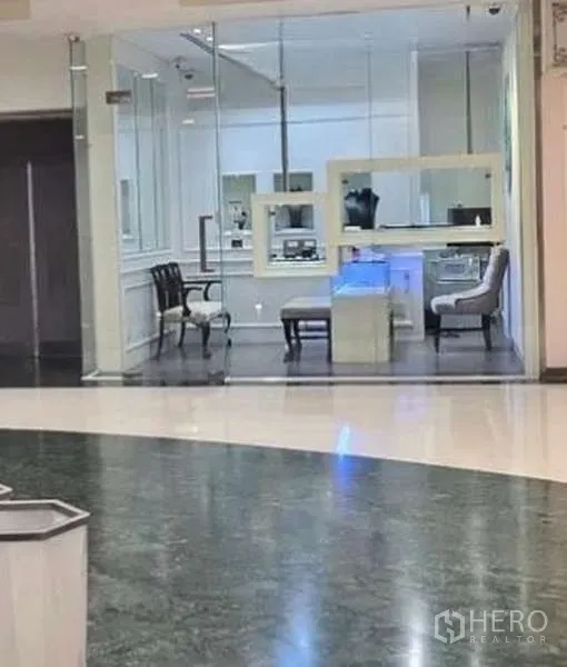Retail Space for rent - Glass-front retail unit with white interiors, display counters and seating, viewed from a mall corridor.