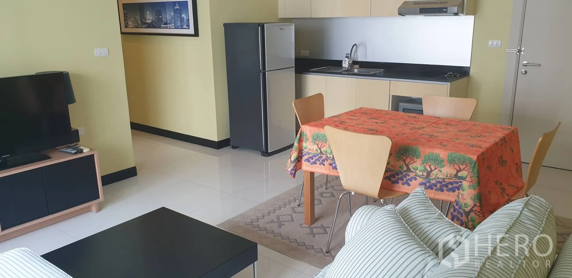公寓 出租在Khlong Toei, Bangkok - 开放式客餐厅，面对电视，后方为用餐区与小厨房。