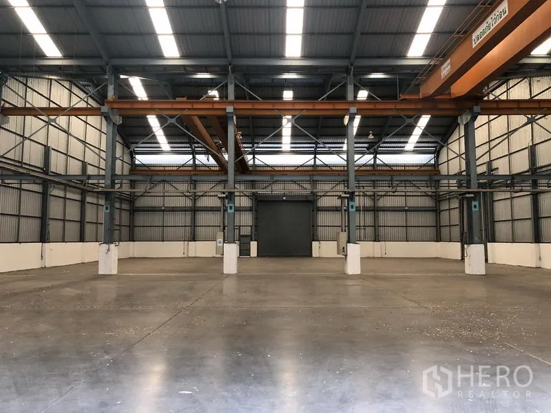 Factory for rent in Khlong Luang, Pathum Thani - Clear-span warehouse floor with polished concrete and central loading door.