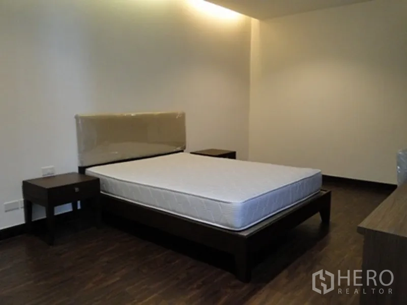 公寓 出租在Watthana, Bangkok - 温馨卧室，木质床架、床头柜与深色木地板