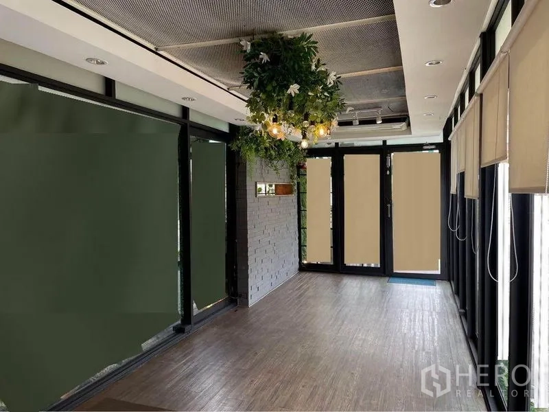 Retail Space for rent in Watthana, Bangkok - Bright retail interior with wood flooring, glass storefront, hanging greenery lights and roller blinds.