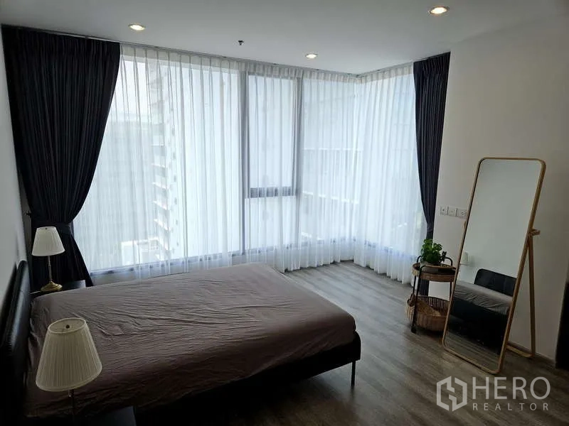 公寓 出租在Bang Na, Bangkok - 转角主卧，落地窗与遮光窗帘，配全身镜。