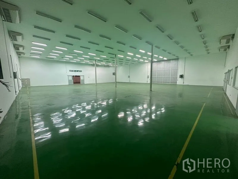 Warehouse for rent in Suan Luang, Bangkok - Warehouse interior with marked floor lanes and bright linear lights.