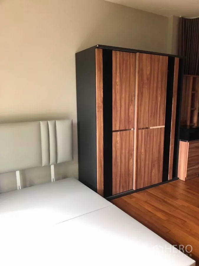 Detached House for rent in Bang Khae, Bangkok - Secondary bedroom with contemporary wardrobe, headboard and warm wood flooring.