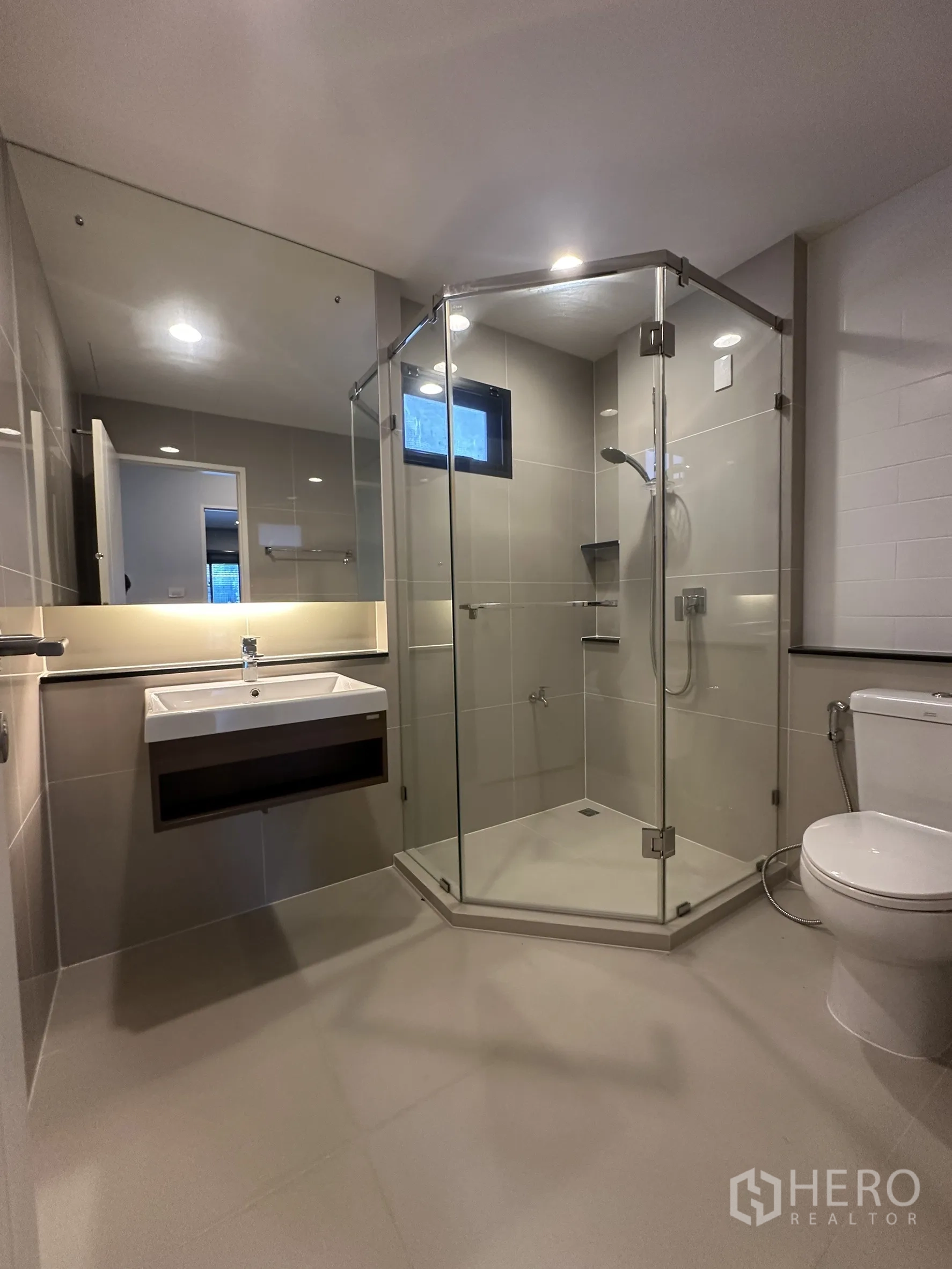 Detached House for rent in Lam Luk Ka, Pathum Thani - Modern bathroom with glass shower enclosure, sink and toilet.