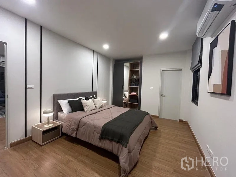 Detached House for rent or sale in Bang Phli, Samut Prakan - Large bedroom showing double bed, twin nightstands and warm wood flooring.