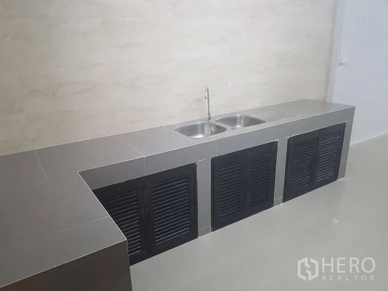 店屋 出租或出售在Lat Phrao, Bangkok - 加长厨房操作台，双水槽与黑色百叶柜门。