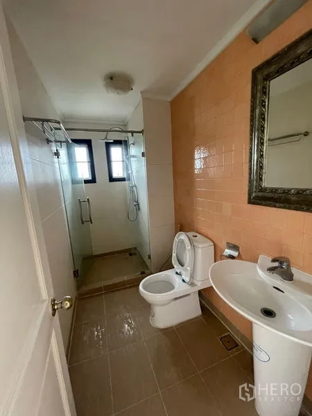 Condominium for rent in Watthana, Bangkok - Shower bathroom with glass enclosure and peach tile feature wall.