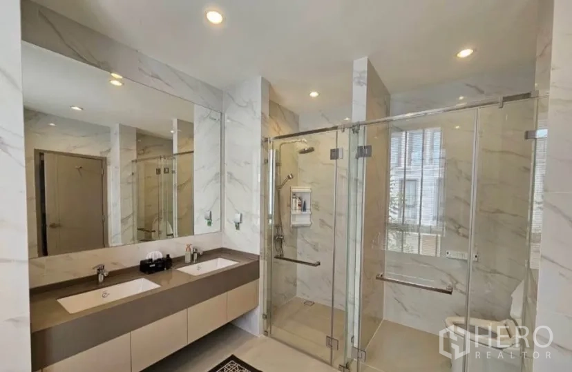 Detached House for rent or sale in Lat Krabang, Bangkok - Marble bathroom featuring twin vanities and glass‑enclosed shower area