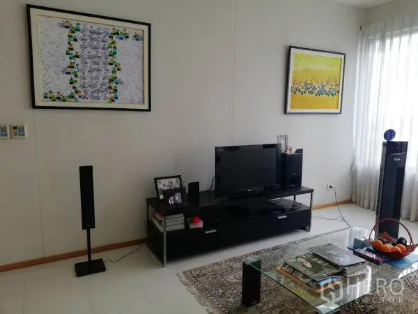 Condominium for sale in Khlong Toei, Bangkok - Media wall in living room with TV, speakers and large windows.