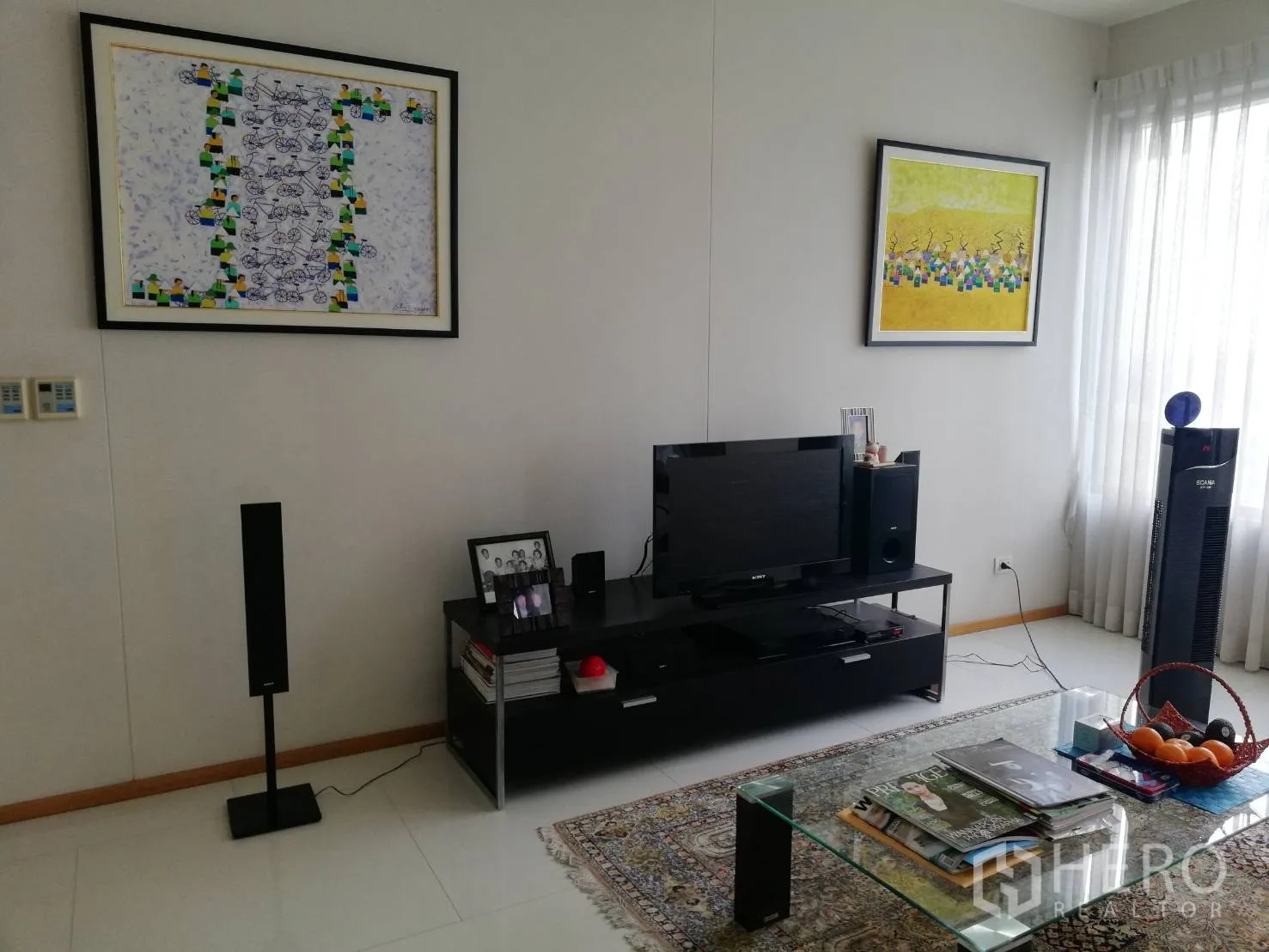 Condominium for sale in Khlong Toei, Bangkok - Media wall in living room with TV, speakers and large windows.
