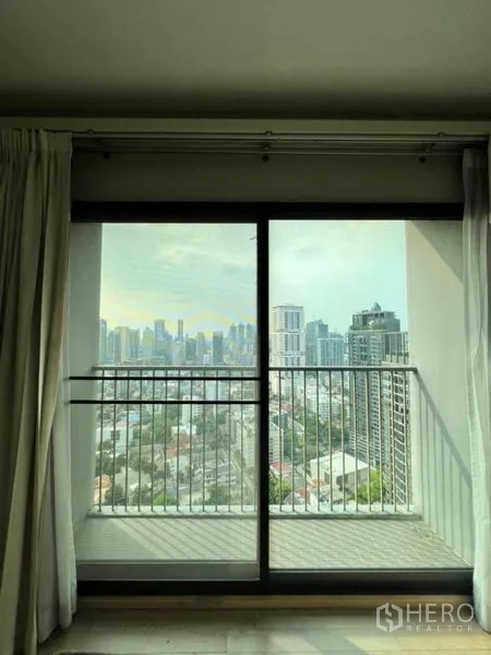 Condominium for rent in Khlong Toei, Bangkok - Balcony sliding door framing a wide Bangkok skyline city view.