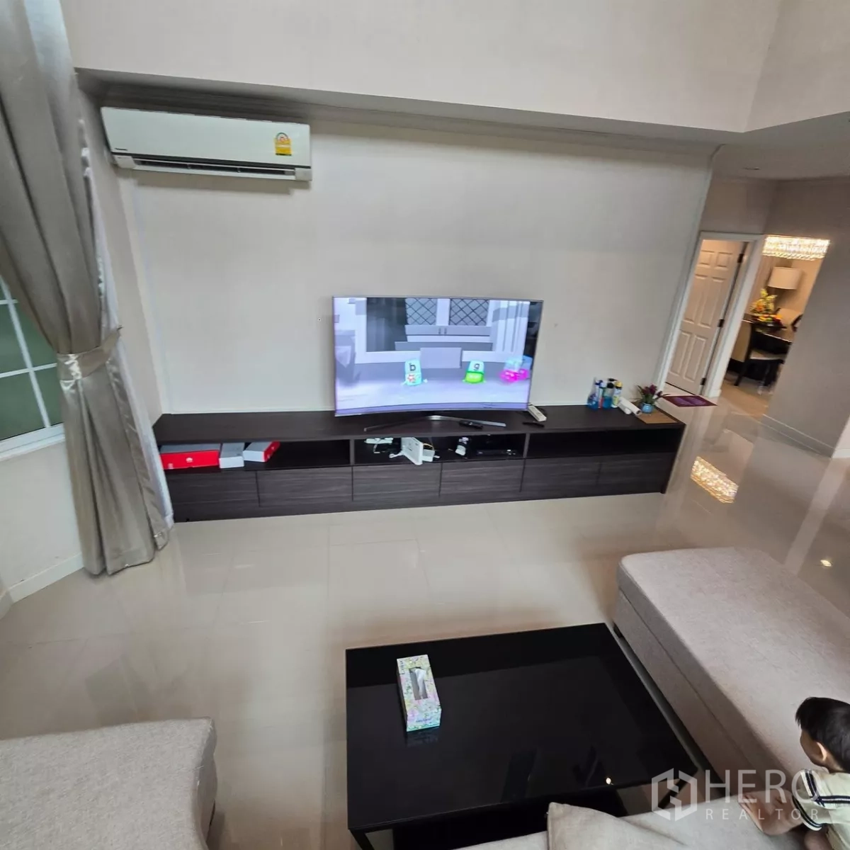 Detached House for rent in Mueang Pathum Thani, Pathum Thani - TV console wall and air conditioner in a sleek modern living room.