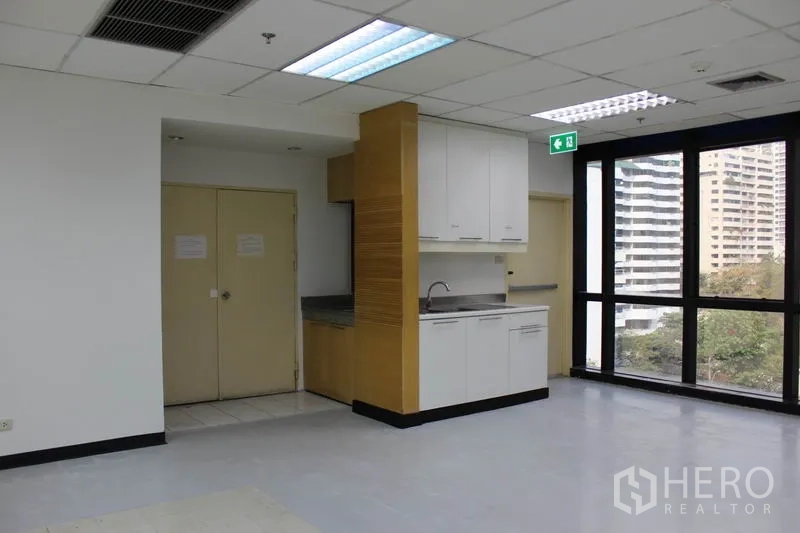 办公空间 出租在Watthana, Bangkok - 办公室内的茶水间，配水槽与橱柜，旁边为大窗。