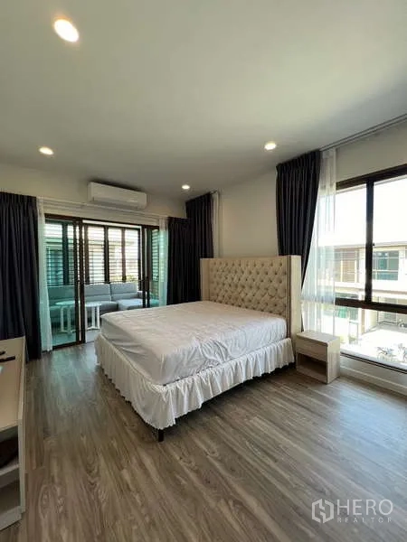 Detached House for rent in Bang Kapi, Bangkok - Master bedroom opening to an enclosed balcony lounge with large windows.