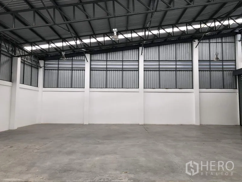 Factory for rent or sale in Pathum Thani - Clear-span warehouse showing metal trusses and blank floor space.