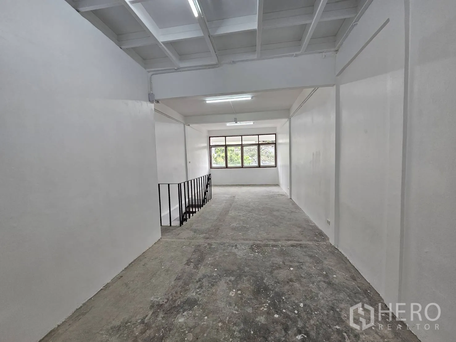 Home Office for rent in Khlong Toei, Bangkok - Bright workspace with white ceiling panels and wide windows.