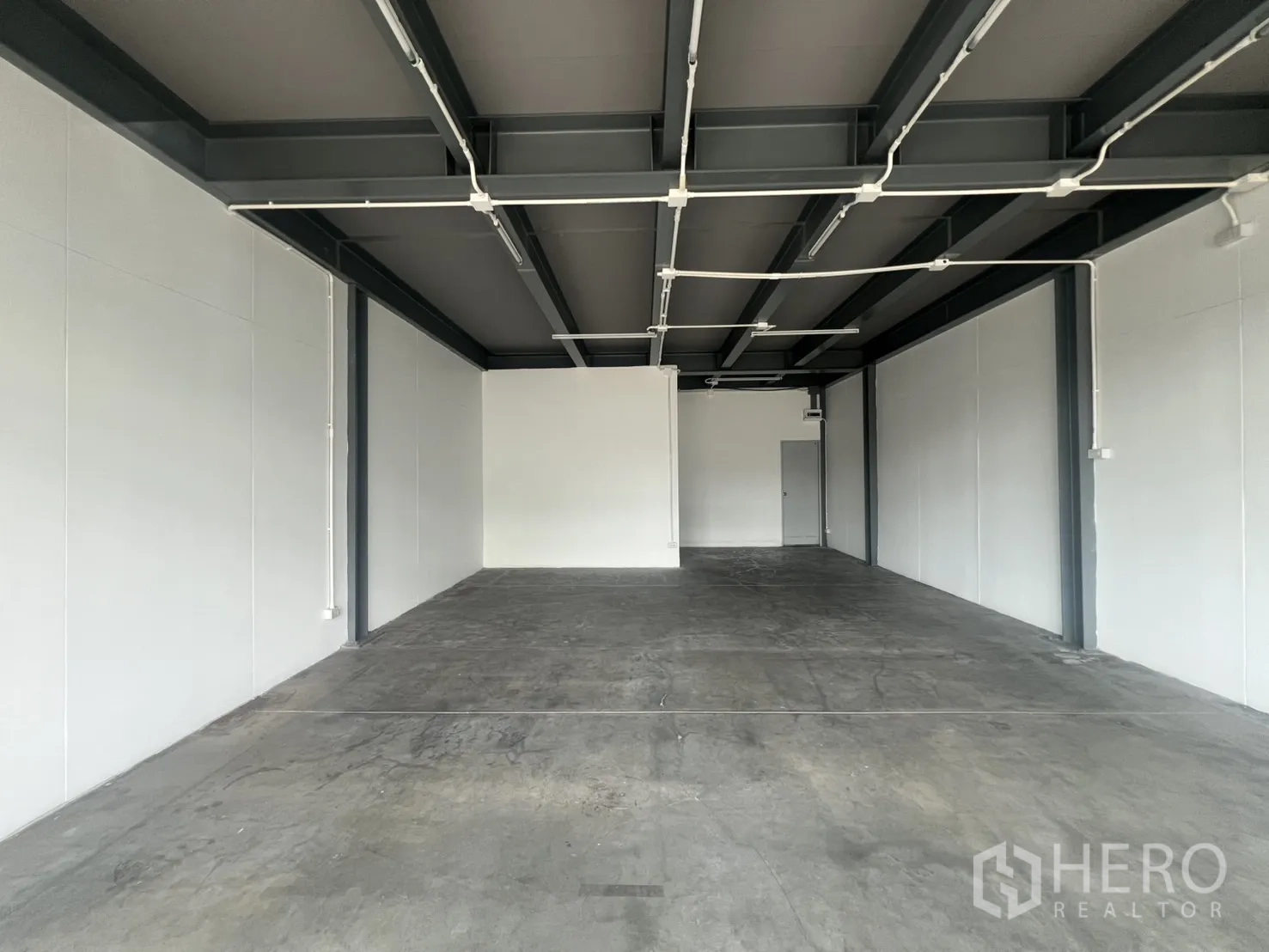 Retail Space for rent in Khlong Toei, Bangkok - Open-plan retail unit with exposed steel beams, concrete floor and white walls.