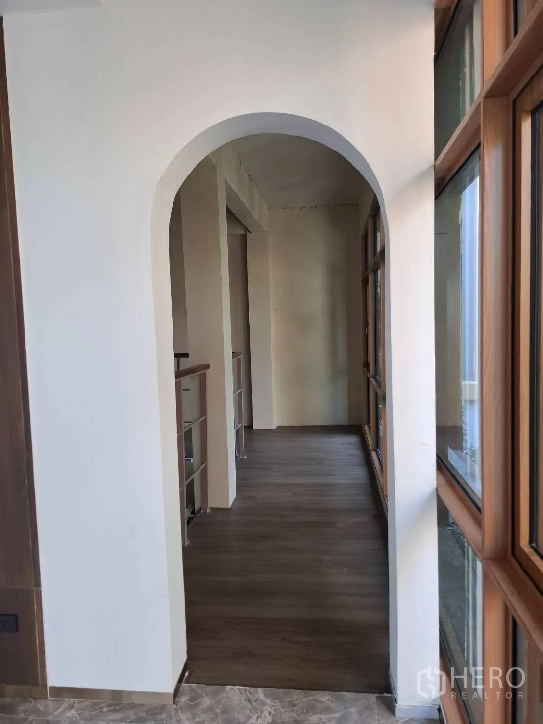 Retail Space for rent in Watthana, Bangkok - Hallway with an arched doorway, wood flooring, and large windows along the side.