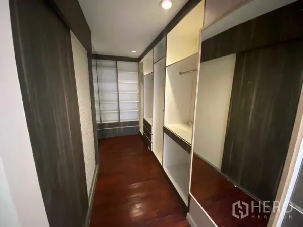Townhouse for rent or sale in Suan Luang, Bangkok - Walk-in closet with built-in shelving and mirrored cabinetry.